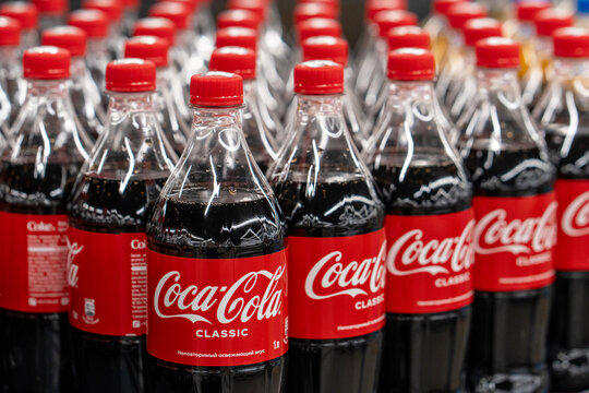 Coca Cola soda bottles in refrigerator on shelves at supermarket, ready for retail sale. Minsk, Belarus - March 31, 2025