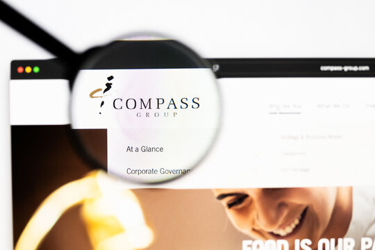 Milan, Italy 2026, 20 Apr Closeup of Compass Group website on a laptop screen. Compass Group logo under a magnifying glass.