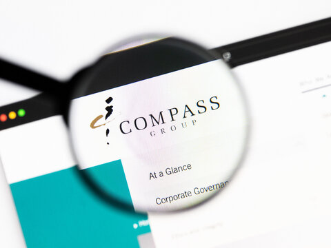 Milan, Italy 2026, 20 Apr Closeup of Compass Group website on a laptop screen. Compass Group logo under a magnifying glass.