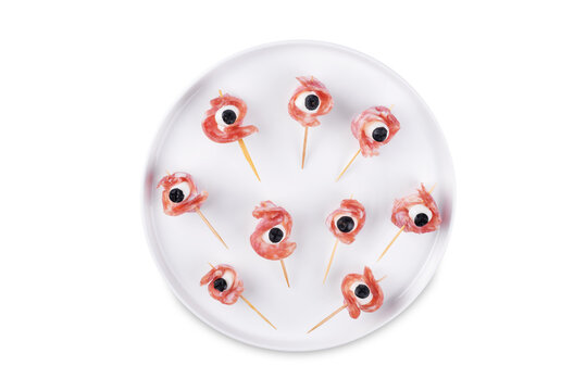 Mozzarella sausage olive canape in the form of eye in a plate on a white isolated background