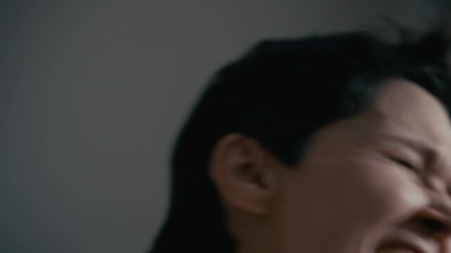 Close up of middle aged Caucasian woman screaming and shaking head in panic during mental breakdown. Clip is suitable for psychiatric clinic promos or mental health awareness campaigns