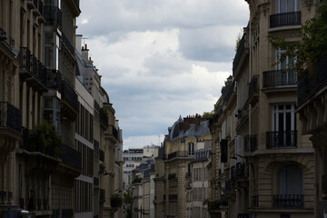 Fototapeta premium Paris haussmann buildings line an urban street with clouds