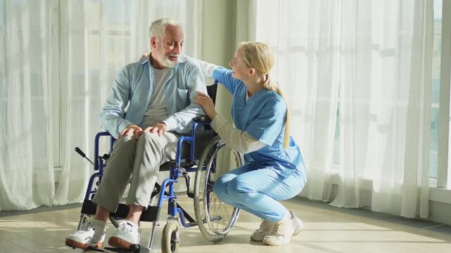 Help support retirement healthcare. Nurse helping old man in wheelchair. Patient and woman in nursing home for medical caregiver. Nurse taking care of paralyzed man in chair for people with disability