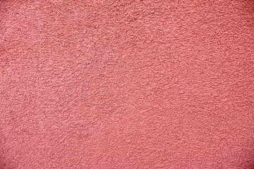 Fototapeta premium Dusty pink granular stucco wall texture.