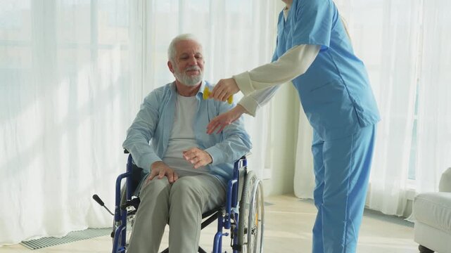 Support rehabilitation healthcare. Nurse helps old man patient in wheelchair picking up dumbbells. Paralyzed man in chair for people with disability doing sports exercise with nurse. Medical caregiver