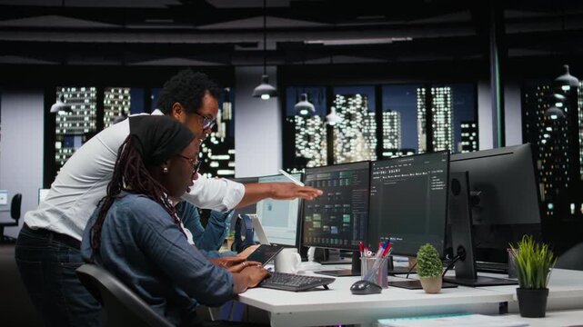 Technicians using PC in office, working with AI programming languages. Coworkers using computer in company workplace to do artificial intelligence tech quality assurance for coding workflows.