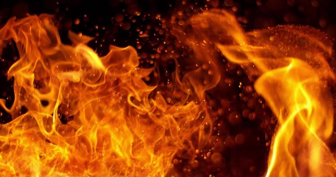Ultra slow motion fire flames with glowing embers and sparks on black background captured at 1000 FPS. Dramatic combustion effect ideal for cinematic overlays and visual effects.