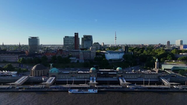 Parallel drone flight from right to left along Landungsbrucken, with the Elbe and Hamburg skyline sliding past in parallax.
