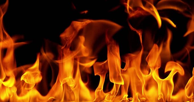 Ultra slow motion fire flames with glowing embers and sparks on black background captured at 1000 FPS. Dramatic combustion effect ideal for cinematic overlays and visual effects.