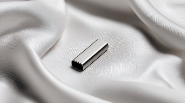 Minimal security dongle on pearl silk, isolated rectangular form placed on smooth drape with clean highlights and soft shadows, modern product photography for ecommerce and catalog use