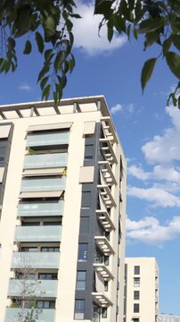 Urban architecture stands tall under sunny sky with scattered clouds