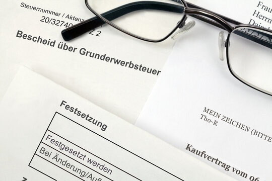Bescheid &uuml;ber Grunderwerbsteuer und notarieller Kaufvertrag mit Lesebrille
