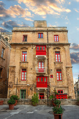 Obraz premium Street view of famous building with maltese red balconies and windows at downtown of Valletta. Malta
