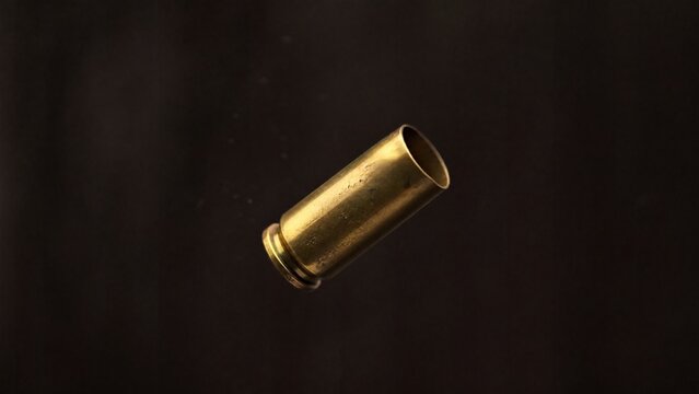 ejected. Single brass cartridge case ejected from an antique revolver, isolated on dark background. mobility guides, transit brochures, designed for mobility and urban transit guides.