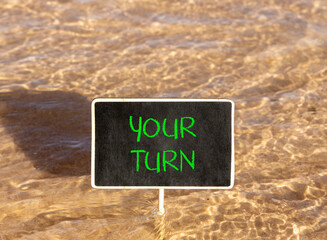 Naklejka premium Your turn words symbol. Concept words Your turn on beautiful black blackboard. Beautiful sea water background. Business your turn motivational support concept. Copy space.