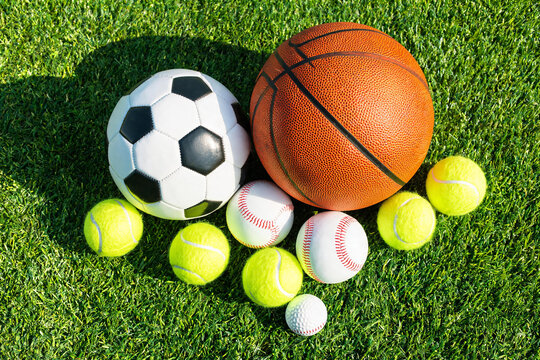 Various Sports Balls Including Soccer, Basketball, Tennis, Baseball, and Golf on Green Grass