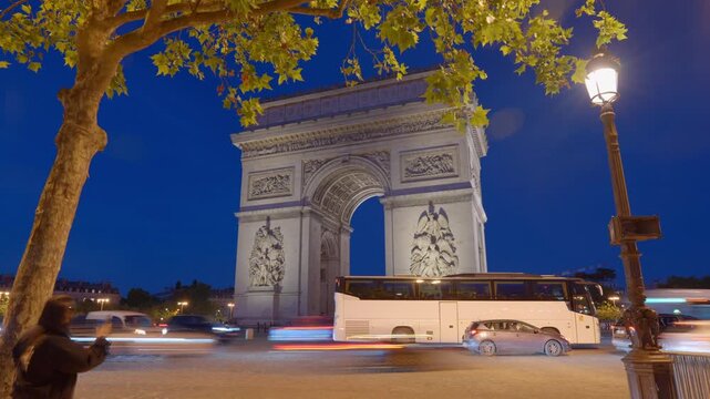 Time lapse view of Arc de Triomphe in Paris, France with blurred cars moving around in foreground. 