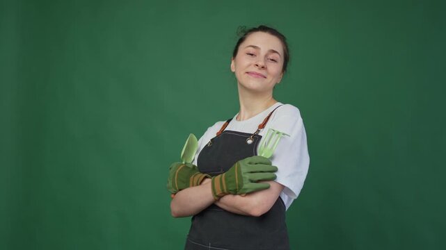 Running of own business. Woman florist gardener farm worker with pruner wearing apron isolated on green background. Happy small business owner working at flower plants shop smiling. Small business