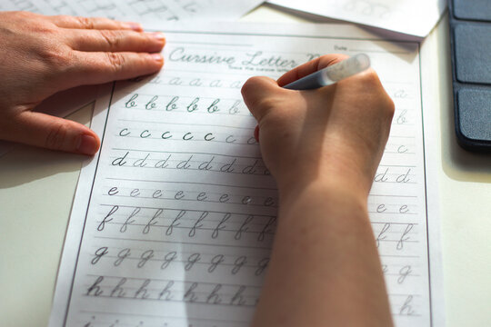 Physical over Digital concept. Woman training calligraphy at desk. Handwriting improves concentration and conceptual understanding better than digital notes. Perfect tool for mental clarity