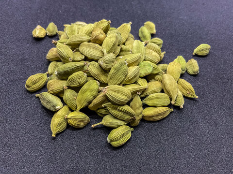 green cardamom pods (Elettaria cardamomum). These aromatic whole spices, known as the "Queen of Spices," feature a vibrant green color and a characteristic textured outer shell