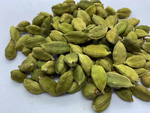green cardamom pods (Elettaria cardamomum). These aromatic whole spices, known as the "Queen of Spices," feature a vibrant green color and a characteristic textured outer shell