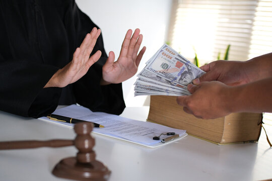 Lawyer is refusing a bribe from his client who is offering him a wad of cash. Full of integrity. Fight against corruption, bribery
