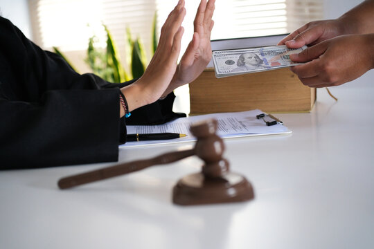 Lawyer is refusing a bribe from his client who is offering him a wad of cash. Full of integrity. Fight against corruption, bribery
