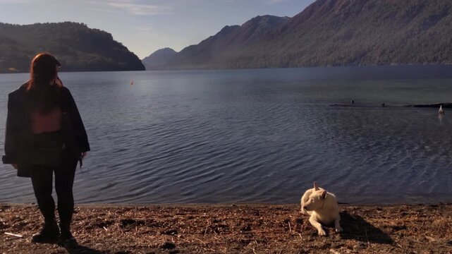 Young Woman and Dog on the Shore of Lake Nahuel Huapi in Villa La Angostura, Patagonia Argentina 