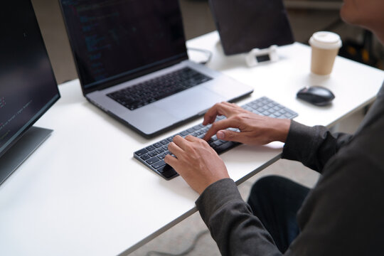 Focused Developer Working on Laptop and Desktop for Software Programming Projects