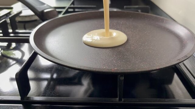 The process of cooking a pancake or crepe on a stovetop. Home life ,kitchen minimalism