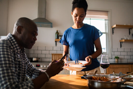 Couple cleaning up after dinner in home kitchen