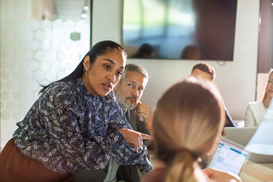 Confident manager leading team discussion in modern office meeting room