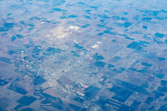 Aerial view of Garden City, Kansas, surrounded by agricultural farmland and the meandering Arkansas River, with Garden City Regional Airport (GCK) visible at lower right, High Plains, Kansas, USA.