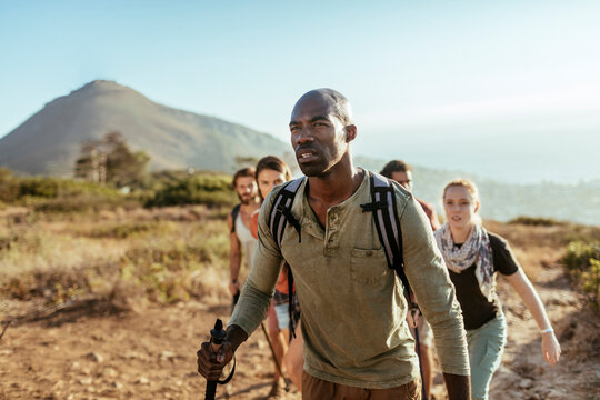 Friends hiking on coastal mountain trail on a sunny day