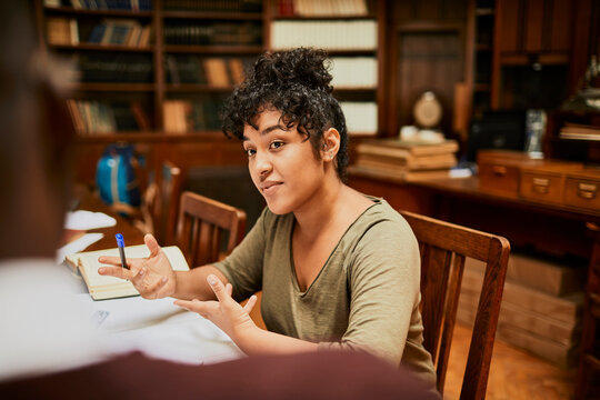 Young student explaining ideas in university library