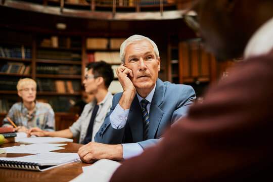 Senior professor listening during study group in library