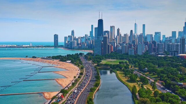 Motorways with hectic traffic and congestions on the shoreline. View on the green park and high-rise skyline of Chicago, Illinois, USA from drone.