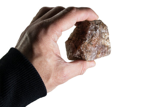 Holding a natural rock stone in hand; on white background