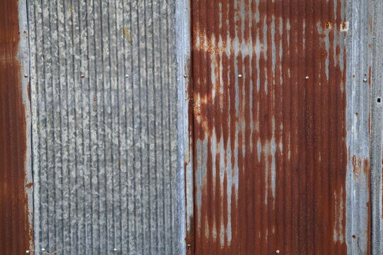 An old and rusty zinc sheet wall. Vintage style metal sheet roof texture. Pattern of old metal sheet. Rusting metal or siding. Corrosion of galvanized. Background and texture in retro concept