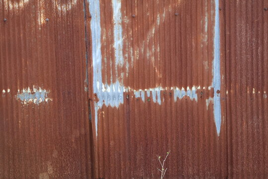 An old and rusty zinc sheet wall. Vintage style metal sheet roof texture. Pattern of old metal sheet. Rusting metal or siding. Corrosion of galvanized. Background and texture in retro concept