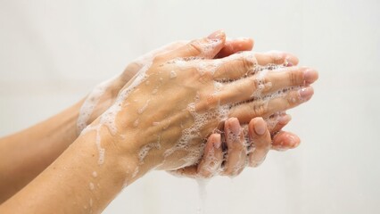 Fototapeta premium Woman washing hands with soap bubbles isolated on white background