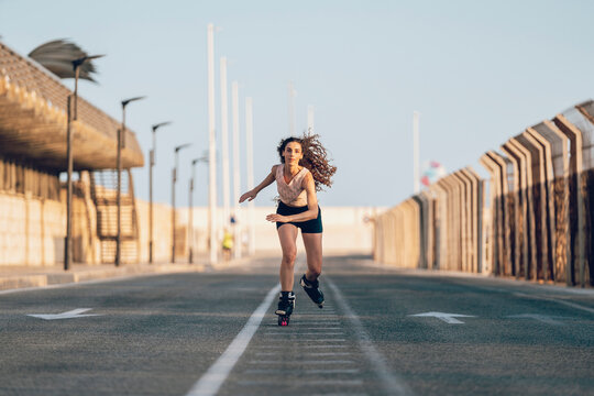 Young woman inline skating on boardwalk at the coast