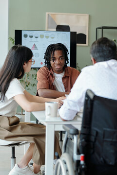 Diverse team in an office brainstorming with a presentation screen