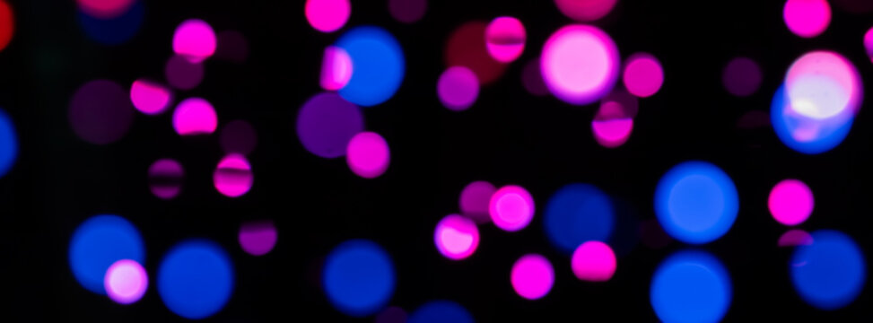 Vibrant Bokeh Lights in Pink, Purple, and Blue Creating a Nighttime Festive Mood
