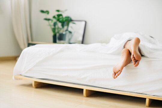 Feet of woman lying in bed