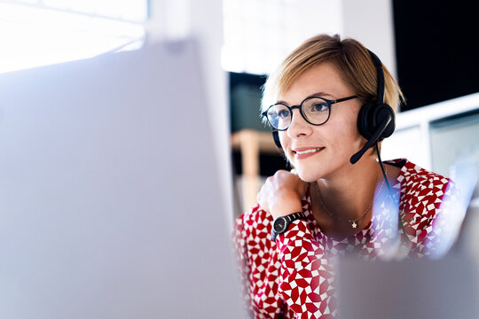 Female customer service representative working on laptop in office