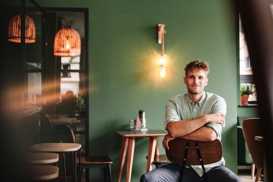 Young business owner sitting in his coffee shop