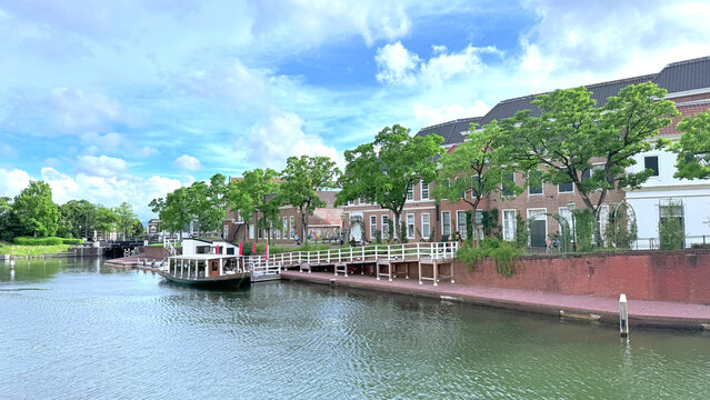 Scenic canal-side view with a boat and European-style brick buildings in Huis Ten Bosch, Japan