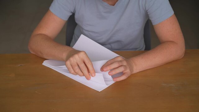 Woman flipping through sheets of paper at a table, high quality audio recording. Soft rustling page sounds and natural hand movement. Office work, study and everyday lifestyle concept.