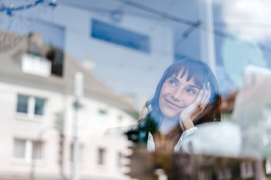 Businesswoman sitting in cafe, daydreaming